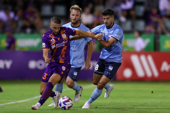 Adam Zimarino of the Glory controls the ball under pressure from Paulo Retre of Sydney FC.