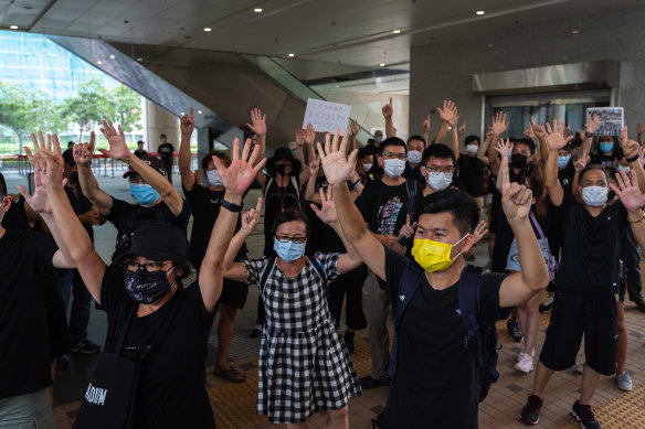 Pro-democracy supporters raise their hands outside the West Kowloon Law Courts in Hong Kong last week.
