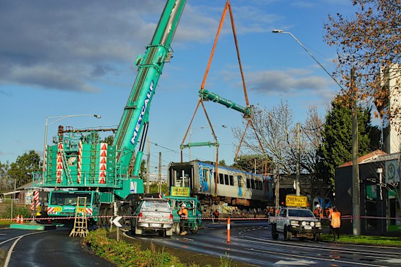 The train carriage is removed from the tracks on Tuesday afternoon after derailing at Clifton Hill on Sunday evening.