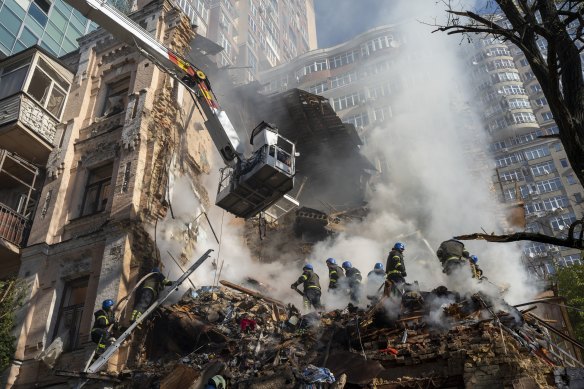 Firefighters work after a drone attack on buildings in Kyiv, Ukraine, on October 17