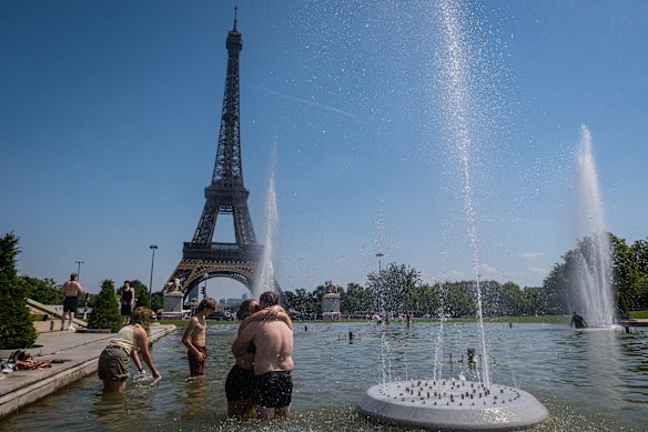 People cool off in front of the Eiffel Tower in Paris.