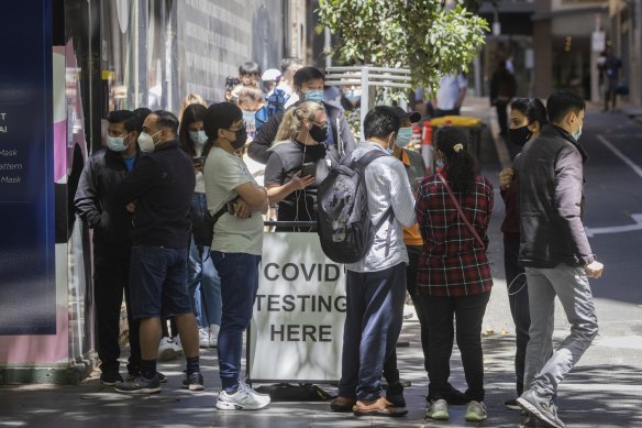 Long lines of people wait to get a COVID-19 test at a Bourke Street clinic.