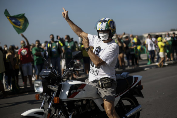 A supporter of the Brazilian President Jair Bolsonaro making a gun sign takes part in a rally in Rio de Janeiro.