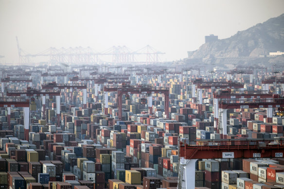 Shipping containers next to gantry cranes at the Yangshan Deepwater Port in Shanghai, China, on Monday, Jan, 11, 2021. U.S. President Donald Trump famously tweeted that “trade wars are good, and easy to win” in 2018 as he began to impose tariffs on about $360 billion of imports from China. Turns out he was wrong on both counts.
