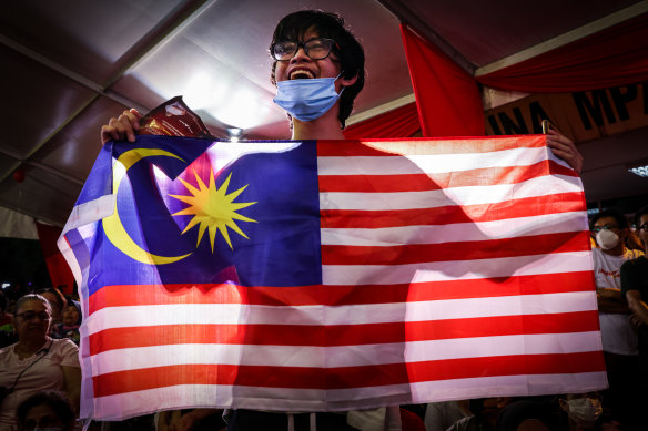 A supporter of Malaysia’s opposition leader Anwar Ibrahim holds a Malaysia flag during an election campaign rally on November 16.