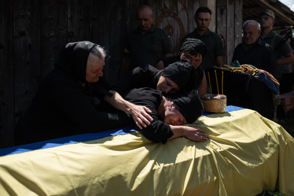 Maryna Hrynchuk, 27, wife of Oleksandr Hrynchuk cries over his coffin after his memorial service on June 27, 2022 in Bila Krynytsia, Ukraineafter he was killed on June 21 in the Luhansk region. 