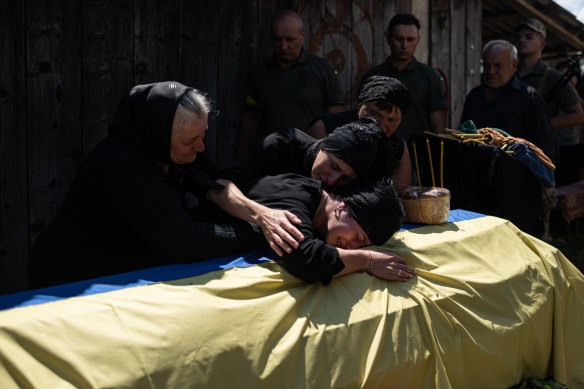 Maryna Hrynchuk cries over her husband’s coffin. He was killed in the Luhansk region.