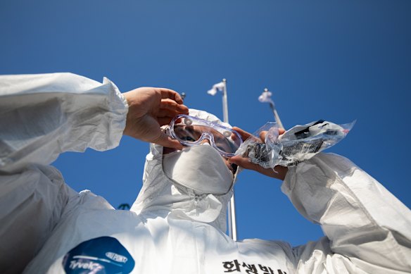 A South Korean soldier adjusts his goggles before setting off on a disinfecting mission as part of South Korea's multibillion-dollar coronavirus blitz.