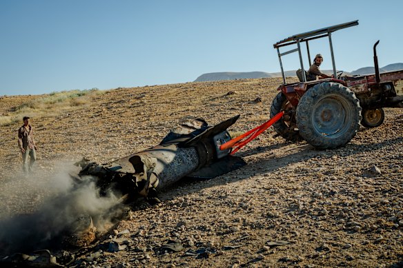 Israeli settlers use a tractor to haul away a large section of a downed Iranian missile on the outskirts of Jericho on Monday.