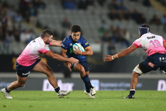 Stephen Perofeta in action for the Blues is tackled against the Melbourne Rebels at Eden Park.