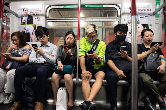 Passageiros viajando no MTR de Hong Kong. 