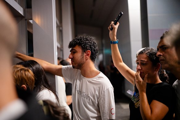 Supporters watch as the Iranian women’s soccer team arrive at Sydney International Airport, before the players departed for Iran.