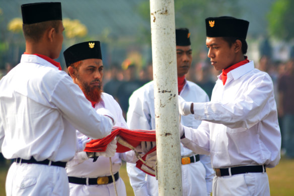 Convicted terrorist Umar Patek (second from left) carries the flag at a ceremony to mark Independence Day in 2017.