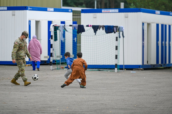 A US soldier plays football with recently arrived Afghan refugees in Germany last month.