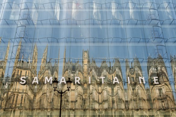 A wavy glass facade, designed by SANAA, reflects neighboring buildings at the La Samaritaine department store in Paris.