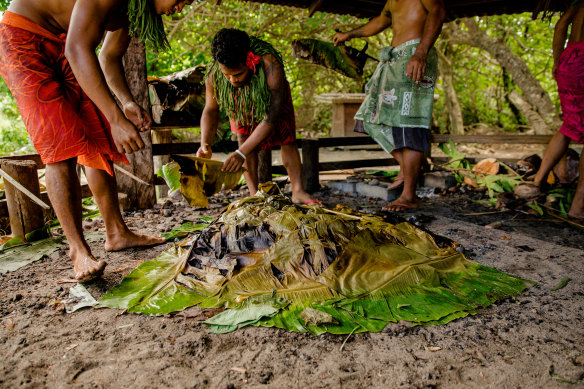 Food is prepared in a traditional umu earth oven in Samoa. 