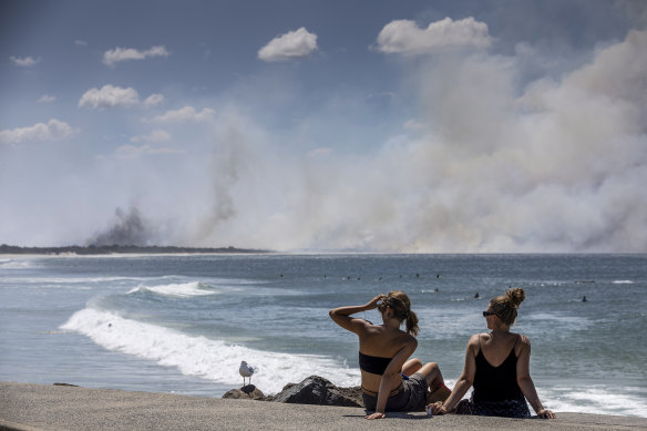 Byron Bay beachgoers watch as the bushfire burns nearby.