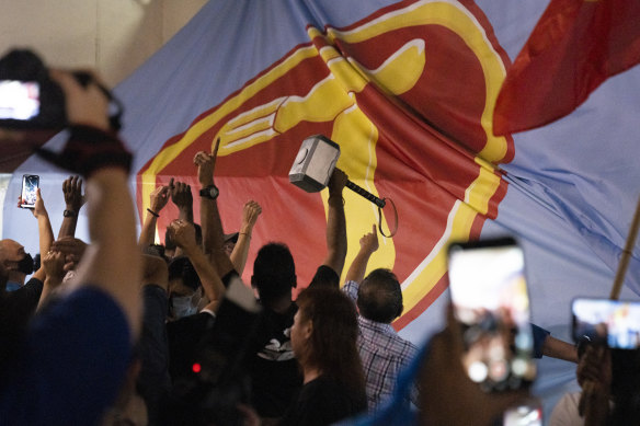 Supporters of the opposition Workers' Party rejoice against the backdrop of a party banner as results are announced.