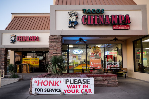 A sign instructs customers to wait in their cars outside a restaurant in El Paso, Texas' worst spot for COVID infections.