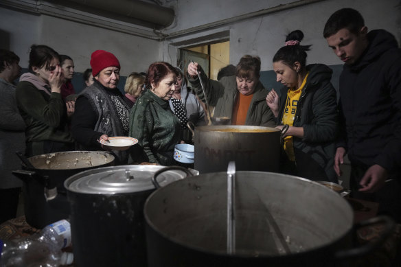 People queue to receive hot food in an improvised bomb shelter in Mariupol, Ukraine on March 7. 