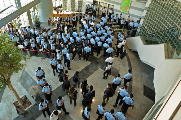 Police officers gather at the lobby of headquarters of Apple Daily in Hong Kong on Thursday. 