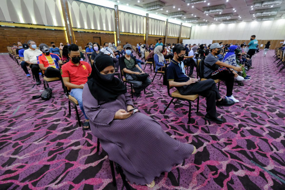 Malaysians waiting after they’ve received their first shot of AstraZeneca in Selangor. 