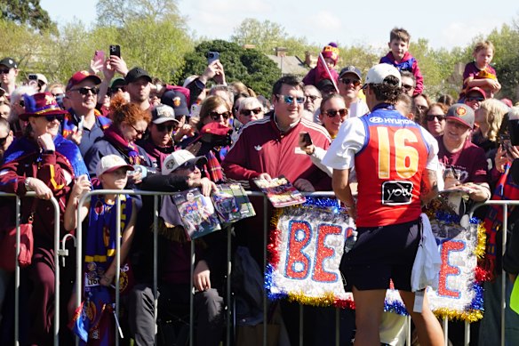 Brisbane Lions player Cam Rayner signs autographs while greeted by fans at the Brunswick Street Oval fans day in Fitzroy after winning the 2026 AFL Grand Final.