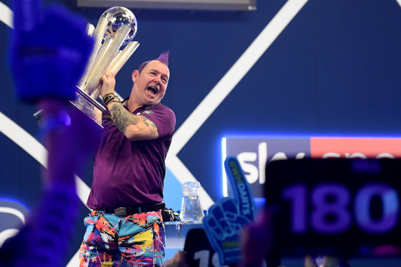 Peter Wright lifts the trophy after winning the world darts championship.