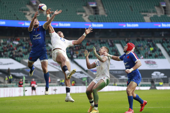 France’s Baptiste Couilloud  and England’s Anthony Watson contest a high ball during the Autumn Nations Cup final in December 2020. 