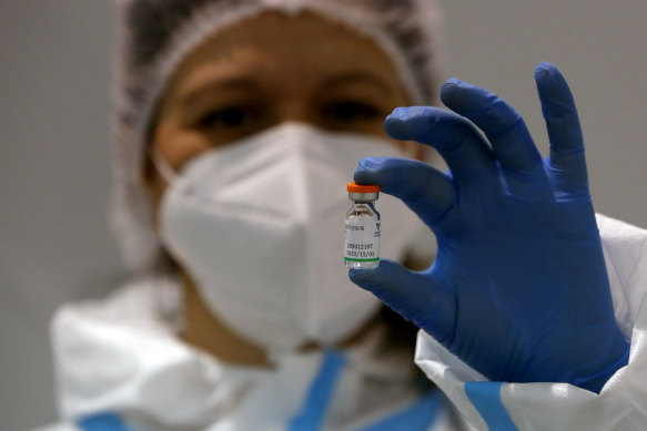 A medical worker poses with a vial of the Sinopharm’s COVID-19 vaccine.