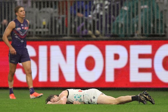 Darcy Byrne-Jones of the Power on the turf after his run-in with Alex Pearce.