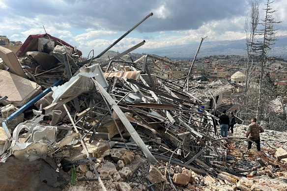 يفحص الناس الأضرار التي خلفتها الغارات الجوية الإسرائيلية المتأخرة ليلة الجمعة في قرية النبي شيت.