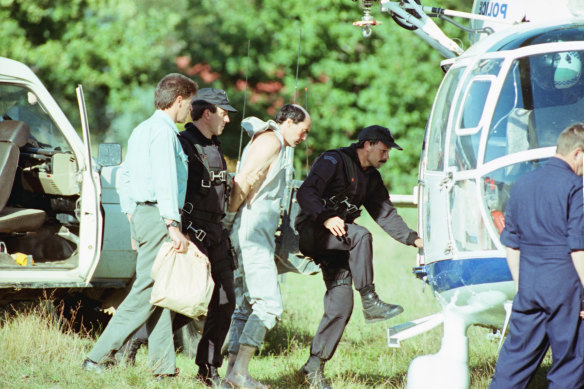 Peter Gibb being loaded into the police helicopter after being recaptured.