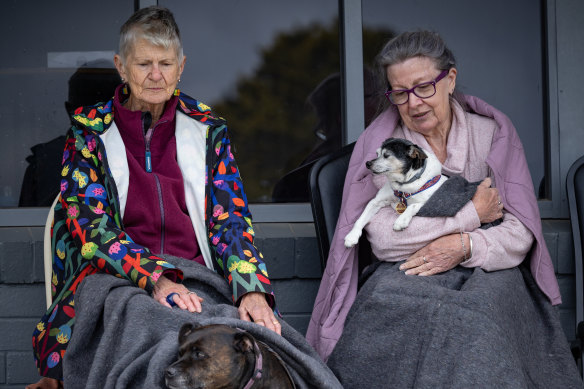 Beaufort residents Gail Hall and Ruby the dog and Judy Cox with Wilbur wait to hear some news after bushfire forced them to evacuate to Ballarat on Thursday.