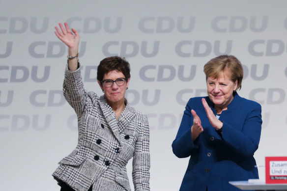 Angela Merkel, then chancellor and outgoing Christian Democrat Union leader, right, applauds Annegret Kramp-Karrenbauer on being elected to lead the party in 2018.