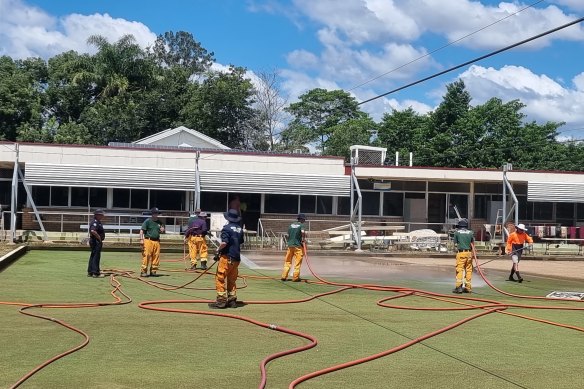 Workers help with the clean-up at a bowls club. 