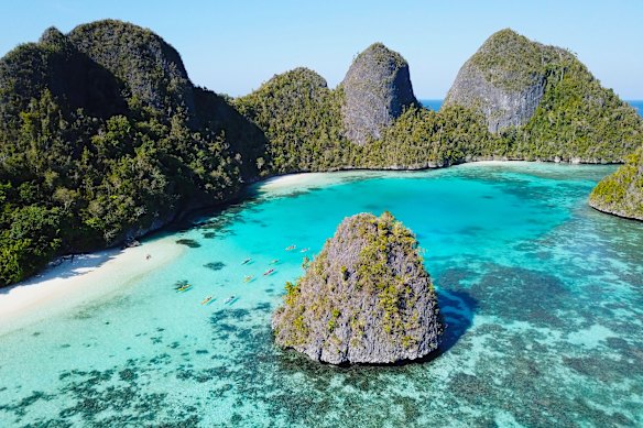 Kayakers circle Raja Ampat’s karst islands.