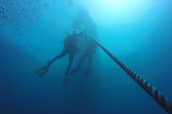 Archaeologists Kieran Hosty of the Australian National Maritime Museum and Irini Malliaros of Silentworld Foundation on the descent line to HMAS Perth in 2019. 