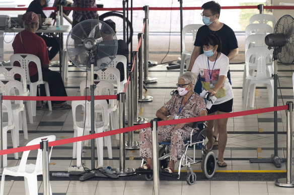 An elderly resident waits to receive her COVID-19 vaccine in Singapore last month. Tens of thousands of people over the age of 60 have still not been vaccinated. 