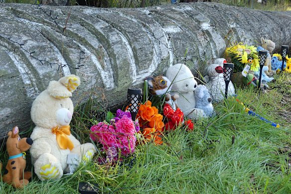 Toys, flowers and candles have been left in tribute near the home in Coonabarabran.