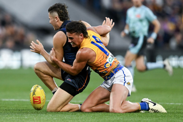 The Crows’ Jake Soligo gets caught holding the ball by West Coast’s Campbell Chesser.