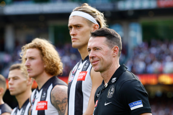 Coach Craig McRae stands alongside Collingwood skipper Darcy Moore during the pre-game ceremony on Anzac Day.
