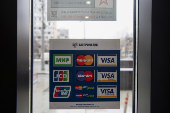 A sign advertises payment services by Visa and Mastercard in the window of the Army of Russia store in Moscow. Both payment services said they would halt operations in Russia.