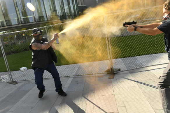 A man sprays mace (left) as another man fatally fires a gun, on Saturday, October 10, 2020 in Denver. The man on the left side of the photo was supporting the "Patriot Rally" and sprayed mace at the man on the right side of the image. The man at right, then shot and killed the protester at left. 