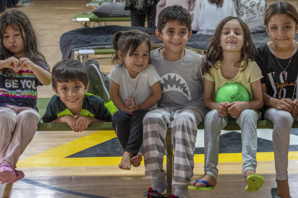 Children pose for a picture in a gym in an undisclosed location in the Middle East after being evacuated by the US Air Force.