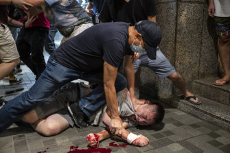 A man is restrained during a protest outside the Citiplaza shopping centre in Hong Kong on Sunday.