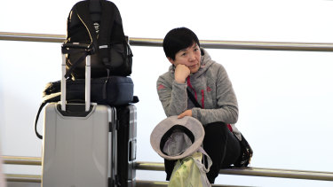 A woman waits after Qantas, Jetstar, Tigerair, Rex and Virgin all cancelled multiple flights.