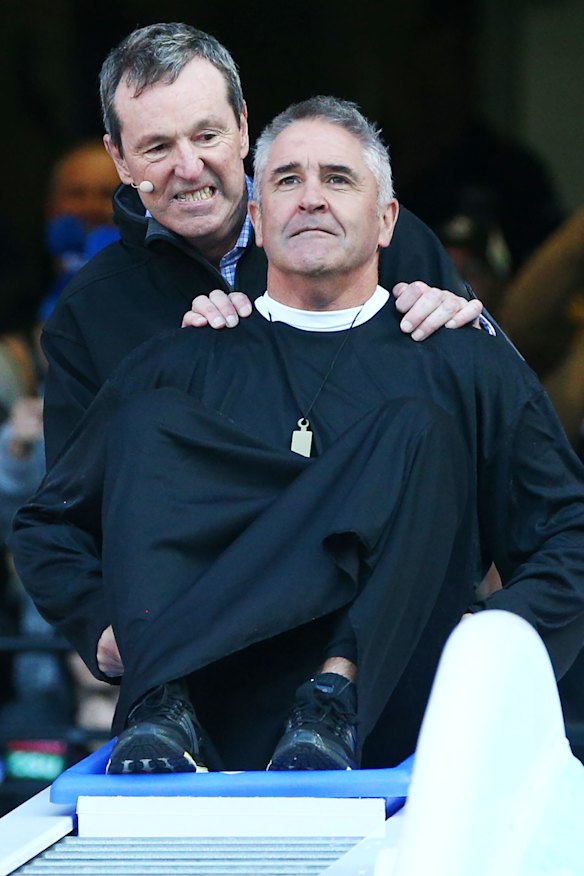 Neale Daniher pushes Fagan – dressed as “the Reverend” (Daniher’s nickname) – down the Big Freeze slide at the MCG in 2018.