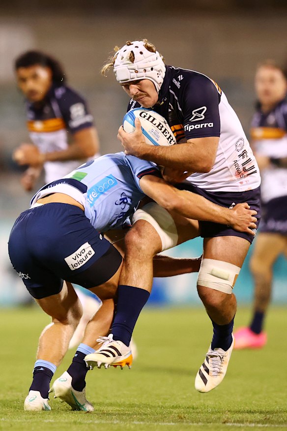 A Waratahs defender stops Rory Scott in his tracks.