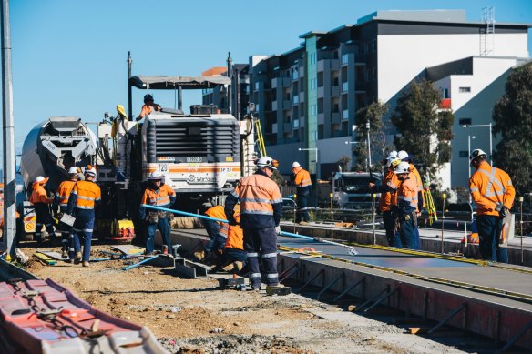 Construction workers laying the light rail concrete slab on Flemington road.